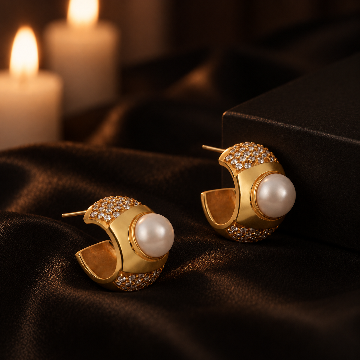 Eva Earrings staged on black satin in warm candlelight
