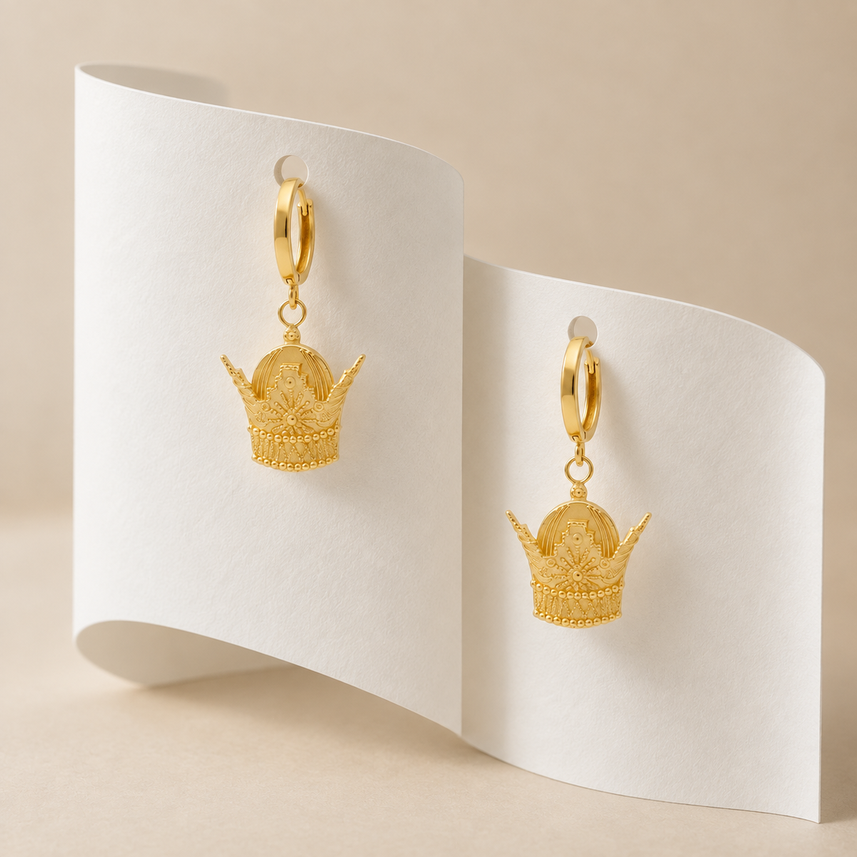 Royal Crown Drop Earrings staged on sculptural white paper