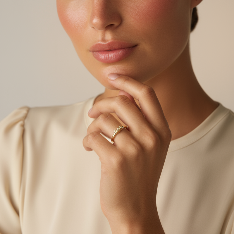 Woman with hand on chin wearing a ring against a neutral background