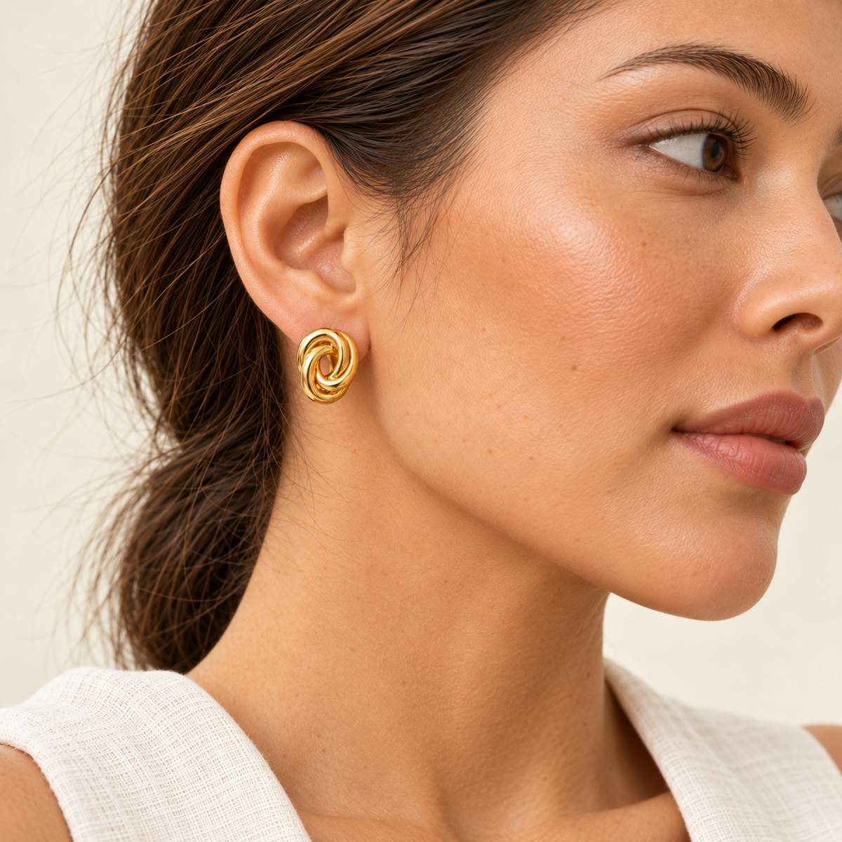 Close-up of a model wearing Aurelia Knot Earrings in 18K yellow gold