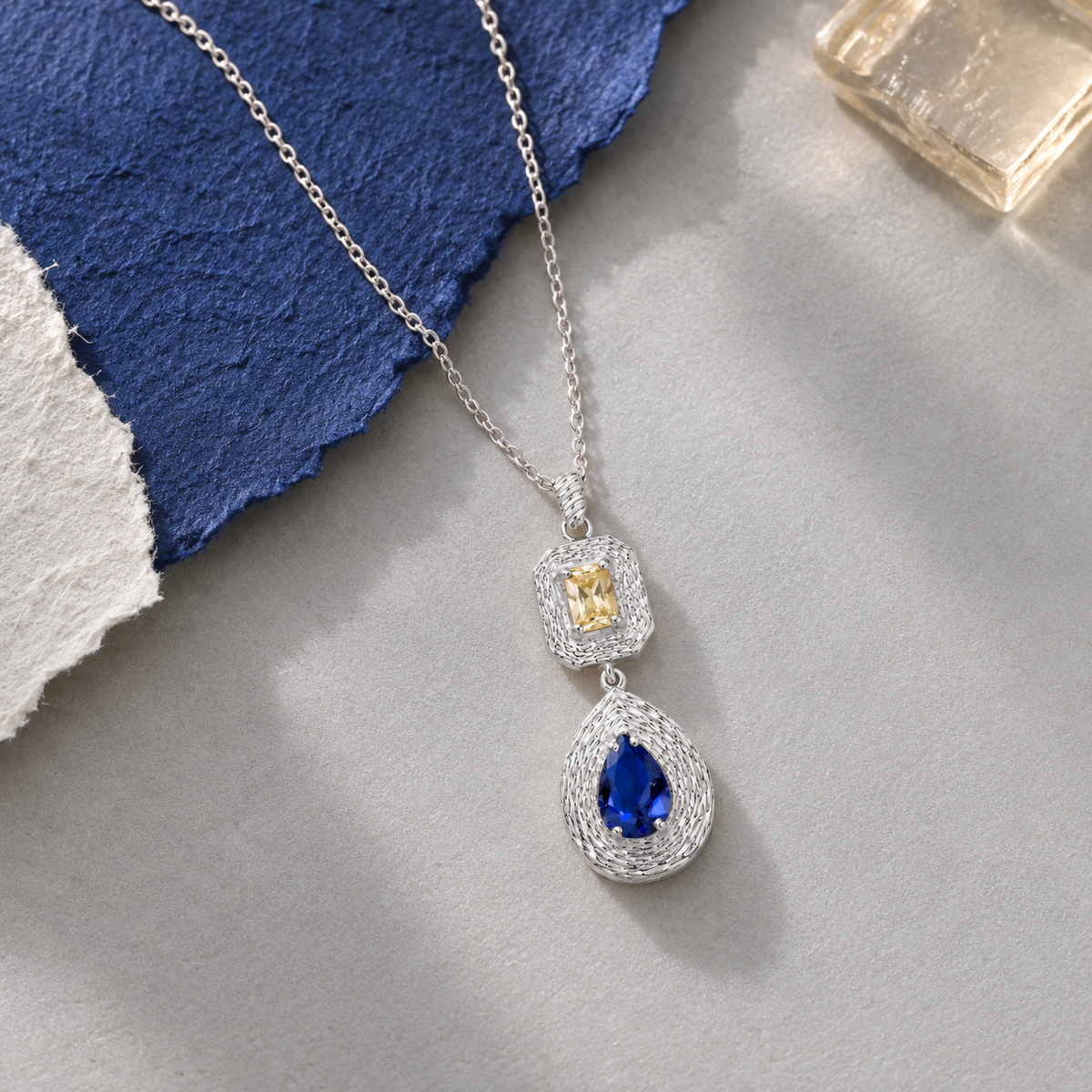 Ava sterling silver necklace with blue and yellow gemstones in a staged composition